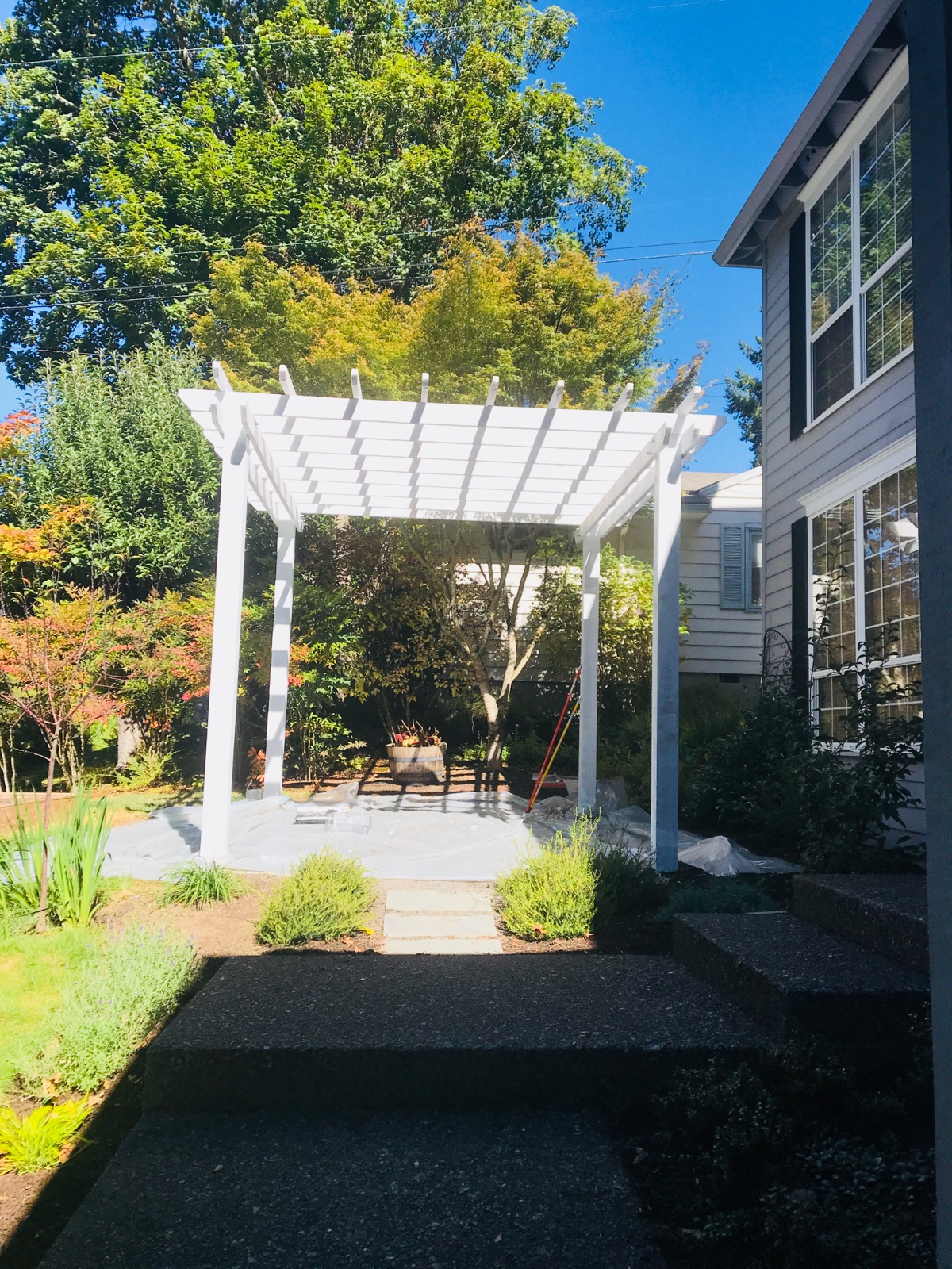 Custom white pergola built onto a backyard patio
